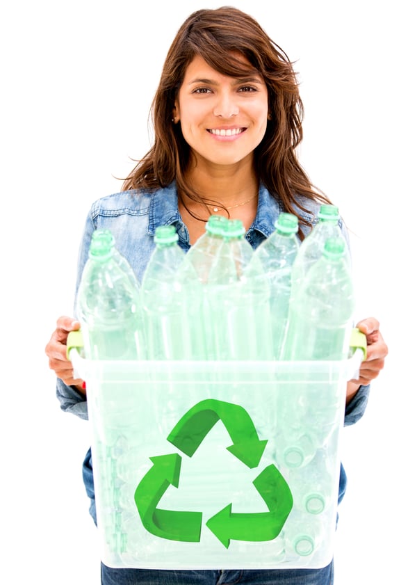 Woman recycling plastic bottles in a bin - isolated over white